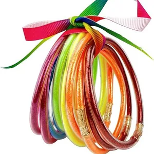 Set of 12 colorful glitter jelly bangles with gold powder tied with rainbow ribbon