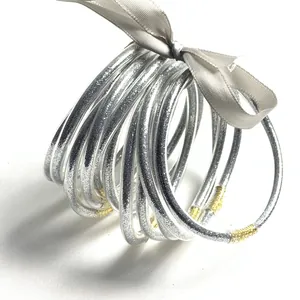 Set van 12 zilveren glitter jelly bangles gebonden met een grijs lint