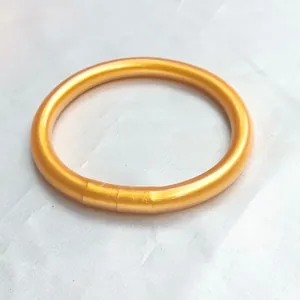 Vue détaillée d'un jonc bouddhiste en silicone doré de 9 mm sur un fond en tissu blanc