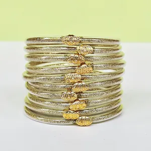Primo piano di 10 bracciali jelly con glitter oro ed eleganti fermagli in metallo a loto.