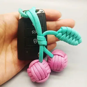 Gros plan d'un porte-clés cerise tissé main avec perles roses et feuilles vertes