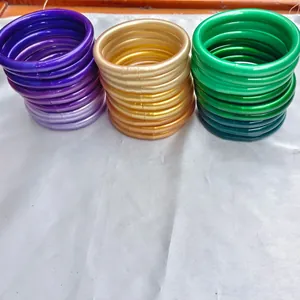 Piles de bracelets joncs bouddhistes en silicone de 9mm en coloris doré, vert et violet.