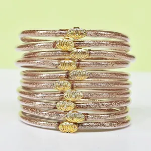 Vista dettagliata di un set di 10 braccialetti jelly con glitter oro rosa e loto