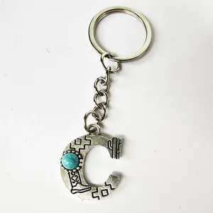Close-up detail of vintage silver stainless steel alphabet C keychain with turquoise