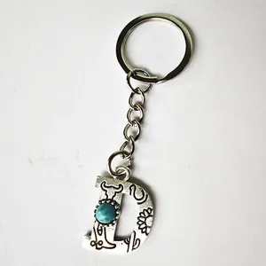 Detailed view of a vintage silver letter D keychain with turquoise and western engravings.