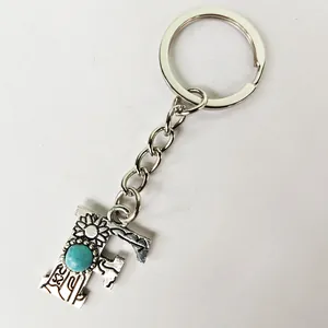Close-up of retro silver letter F keychain with turquoise stone and floral patterns