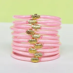 Set di 10 bracciali jelly rosa glitterati con fibbie a loto dorate in vista impilata