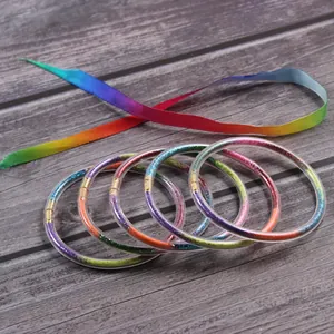 Set of 5 rainbow glitter filled silicone bangles with matching colorful ribbon tie