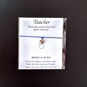 Detailansicht eines Lehrer-Geschenkarmbands mit silbernem Apfelanhänger auf Wunschkarte.