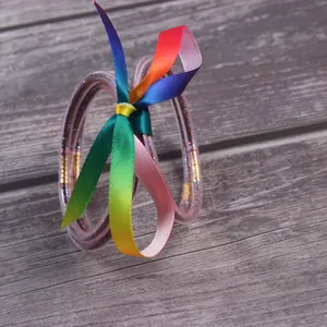 Multilayer silicone glitter bangles set with a vibrant rainbow ribbon bow