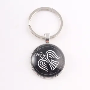 Macro detail of Nordic Viking raven totem on black glass cabochon keychain pendant