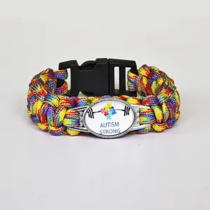 Close-up of a colorful braided paracord bracelet with an Autism Strong puzzle heart charm