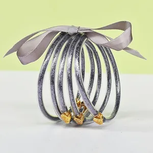 Set of 5 silver glitter silicone jelly bangles with golden lotus clasps and ribbon