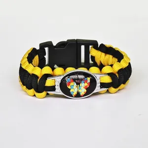 Detail view of yellow and black braided paracord bracelet with puzzle butterfly charm