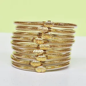 Détail de l'ensemble de bracelets en silicone pailleté or à 9 couches avec lotus.