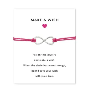 Detail view of hot pink infinity symbol bracelet on 'Make a Wish' greeting card.