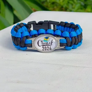 Dettaglio del bracciale in paracord blu e nero con ciondolo di laurea Class of 2024