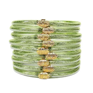 Gros plan de neuf bracelets en silicone à paillettes vertes avec boucles de lotus dorées.