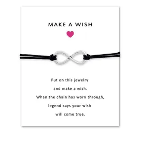 Macro view of infinity symbol bracelet on white wish card with blessing text info.