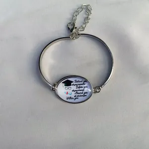 Dettaglio di un bracciale laurea argento con citazione ispiratrice e tocco.