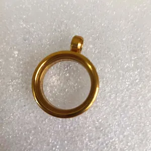 Detalle macro de un colgante de relicario redondo de acero inoxidable dorado con ventana