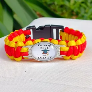 Dettaglio del bracciale in paracord rosso e giallo con ciondolo di laurea 2024
