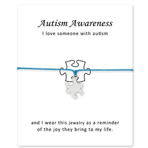 Verzilverde puzzelbedel armband met Autism Awareness kaart aan lichtblauw waskoord
