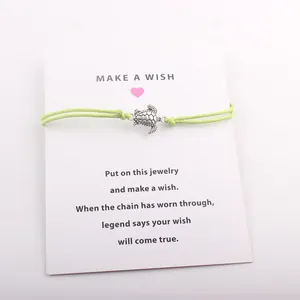 Détail du bracelet tortue sur cordon vert avec une carte de vœux poétique Make A Wish