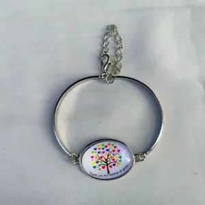 Dettaglio macro del bracciale argento con gemma del tempo e albero di cuori colorati
