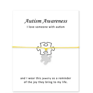Handgemaakte verzilverde puzzelbedelarmband met een geel koord en Autism-kaarten