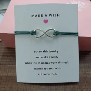 Detail view of the infinity symbol wish bracelet attached to a motivational gift card