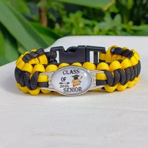 Dettaglio del braccialetto di laurea in paracord intrecciato nero e giallo del 2024