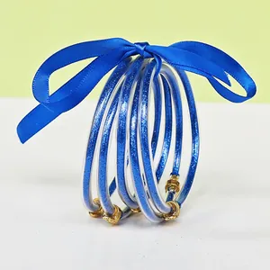 5-piece set of blue glitter silicone jelly bangles with a decorative blue satin ribbon bow