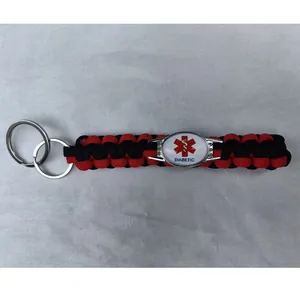 Close-up detail of red and black braided paracord keychain with Diabetic medical alert tag.