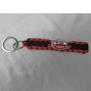 Detailed macro view of medical alert diabetic tag on red and black paracord keychain