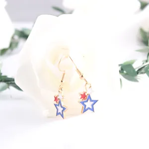 Close-up of star drop earrings featuring American flag colors red white and blue enamel