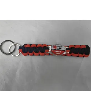 Detail of a red and black paracord keychain with a Diabetic Type 1 medical alert tag.