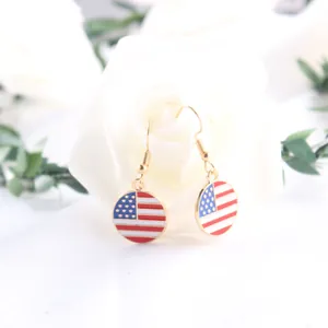 Close-up of gold drop earrings with US flag enamel charm for Independence Day
