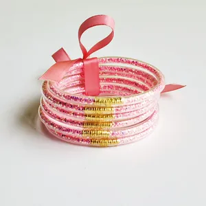 Detail view of 6-layer pink glitter silicone bracelets with a matching ribbon bow tie.