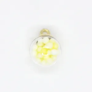 Macro view of 16mm round clear glass pendant filled with yellow and white foam balls