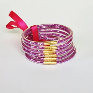 Detailed macro view of 6-piece pink glitter silicone bangles set with a silk ribbon bow