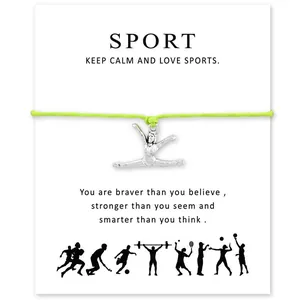 Vue détaillée du charme de gymnastique sur un bracelet vert avec une carte de vœux.