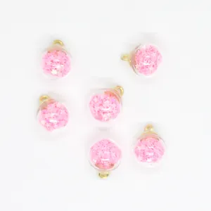 Macro detail of 16mm transparent glass ball charms filled with shimmering pink star sequins