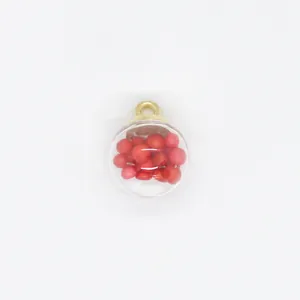 Close-up of a 16mm round transparent jewelry charm filled with small red foam balls.