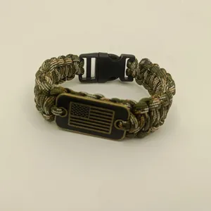 Close-up of paracord bracelet with American flag metal plate and black buckle