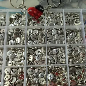 Organized grid of silver metal letter charms with red heart block keychain detail