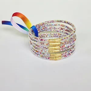 Set of 6 colorful glitter-filled PVC bangles featuring a stylish rainbow ribbon bow.
