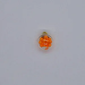 Close-up detail of 16mm transparent round charm filled with vibrant orange foam balls