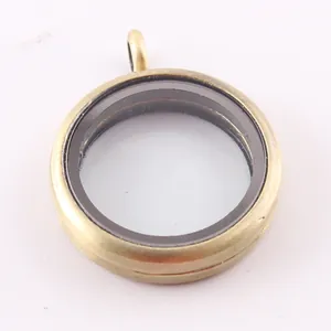 Primo piano di un ciondolo locket rotondo da 30mm in vetro e oro antico per DIY