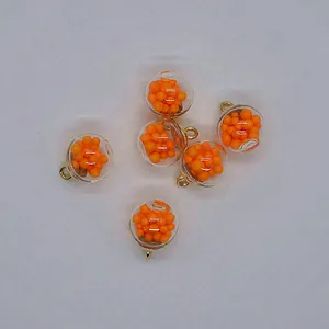 Close-up of 16mm transparent round glass pendants filled with orange foam beads